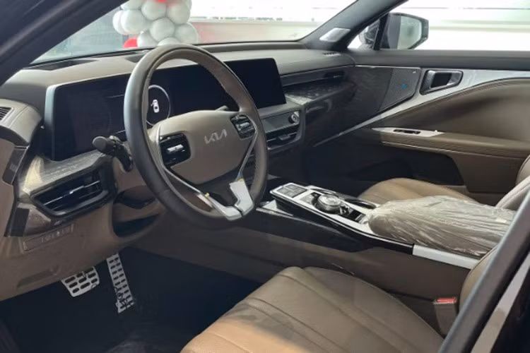 Bên trong Kia K8 là không gian nội thất khá rộng rãi và sang trọng. Tại đây, xe được trang bị mặt táp-lô 2 tầng, vô lăng 3 chấu, màn hình cảm ứng chỉnh điều hòa và nút bấm chuyển số. Đặc biệt, xe còn sở hữu cụm màn hình cong trên mặt táp-lô, tích hợp bảng đồng hồ kỹ thuật số và màn hình thông tin giải trí cùng có kích thước 12 inch.