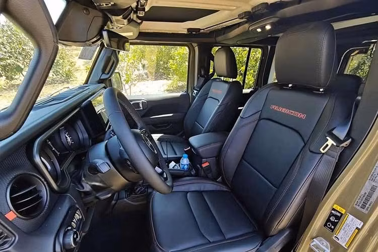 Bên trong nội thất của Jeep Wrangler 2026 lại cho thấy nhiều thay đổi rõ rệt. Nâng cấp đáng chú ý nhất là màn hình trung tâm 12,3 inch hỗ trợ Apple CarPlay và Android Auto không dây, kích thước lớn hơn đáng kể so với màn hình 8 inch trên những xe từng được JVA đưa về Việt Nam.