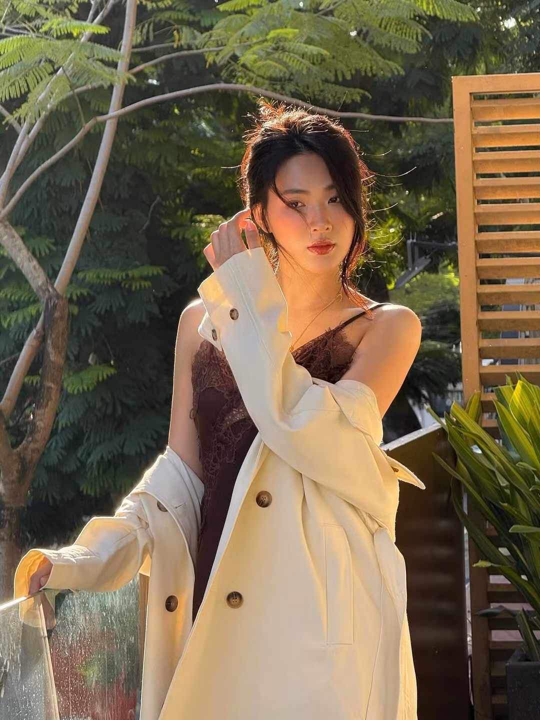 Nữ diễn viên khéo léo khoác hờ một chiếc áo măng-tô màu kem nhạt bên ngoài, tạo nên sự tương phản màu sắc thanh lịch.