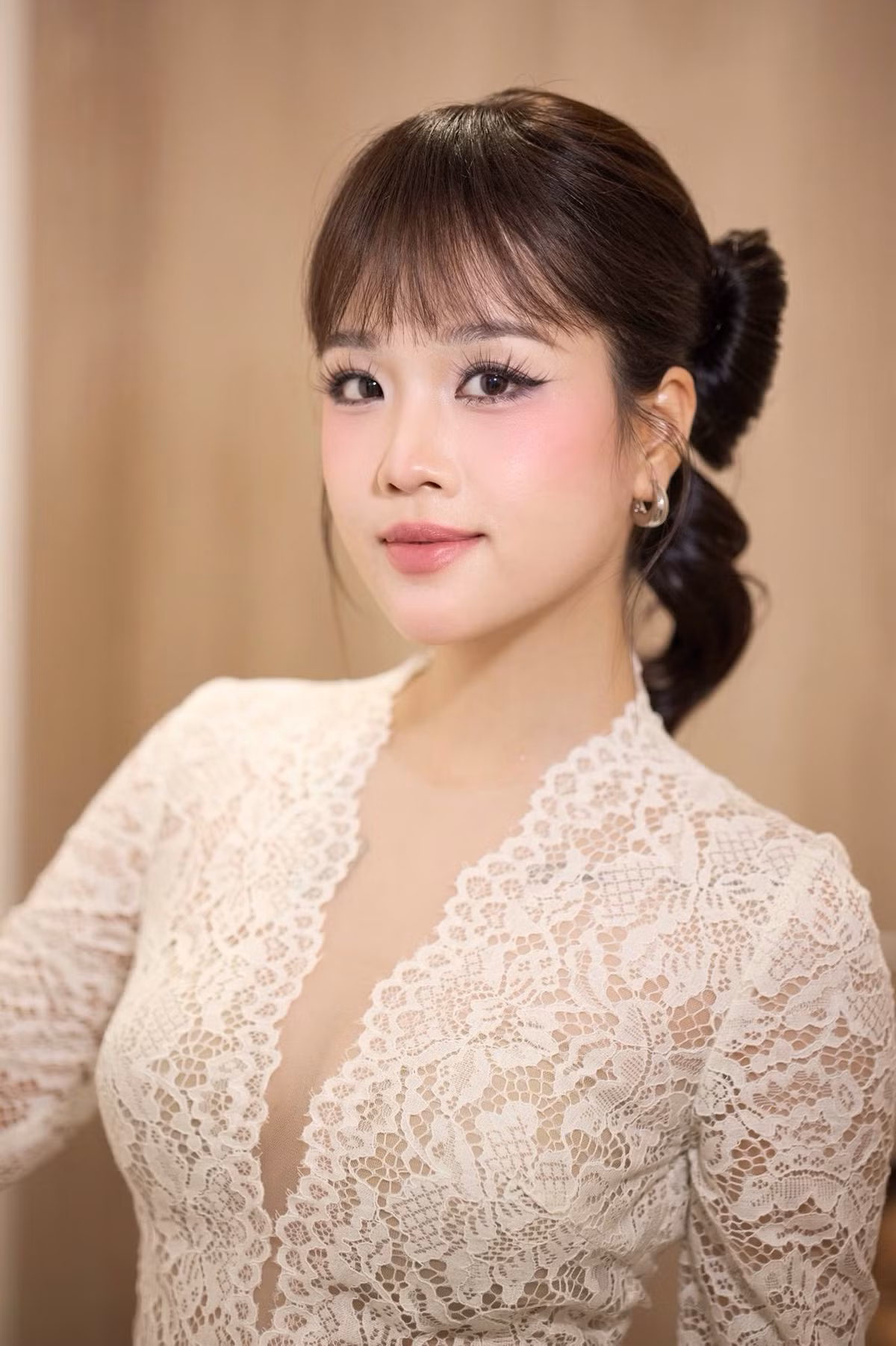 Bộ váy ren trắng của Huyền My là điểm nhấn nổi bật với đường xẻ ngực tinh tế, tôn vẻ đẹp gợi cảm nhưng không phản cảm. Chất liệu ren cao cấp giúp bộ trang phục vừa sang trọng vừa mềm mại.