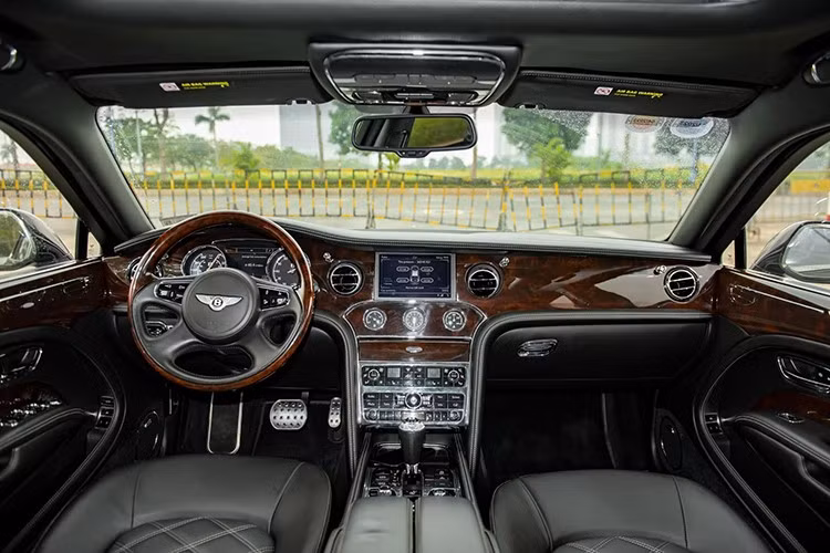Mở cửa bước vào bên trong khoang lái, Bentley Mulsanne Le Mans Edition có dòng chữ Le Mans Edition được thắp sáng trên bậc cửa, ghế ngồi có các đường chỉ câu tương phản trên các khu vực chần kim cương...