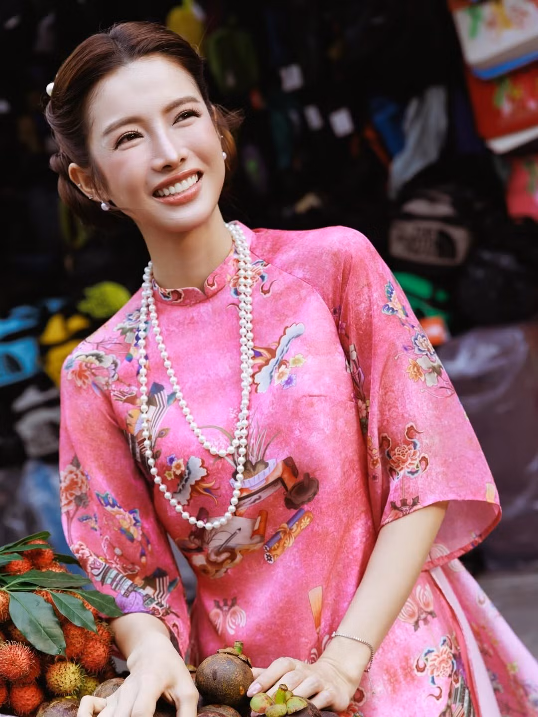 Bộ áo dài màu hồng sen được Mỹ Duyên lựa chọn khéo léo, vừa tôn làn da, vừa mang đến cảm giác trẻ trung, rạng rỡ. Họa tiết cổ điển pha nét hiện đại, kết hợp cùng chuỗi ngọc trai dài và kiểu tóc vấn gọn gàng, giúp tổng thể vừa mang hơi thở truyền thống, vừa có chút hơi hướng thời trang đương đại. Không quá cầu kỳ phụ kiện, chính sự tiết chế này lại làm nổi bật vẻ đẹp thanh lịch, đúng tinh thần áo dài Việt.