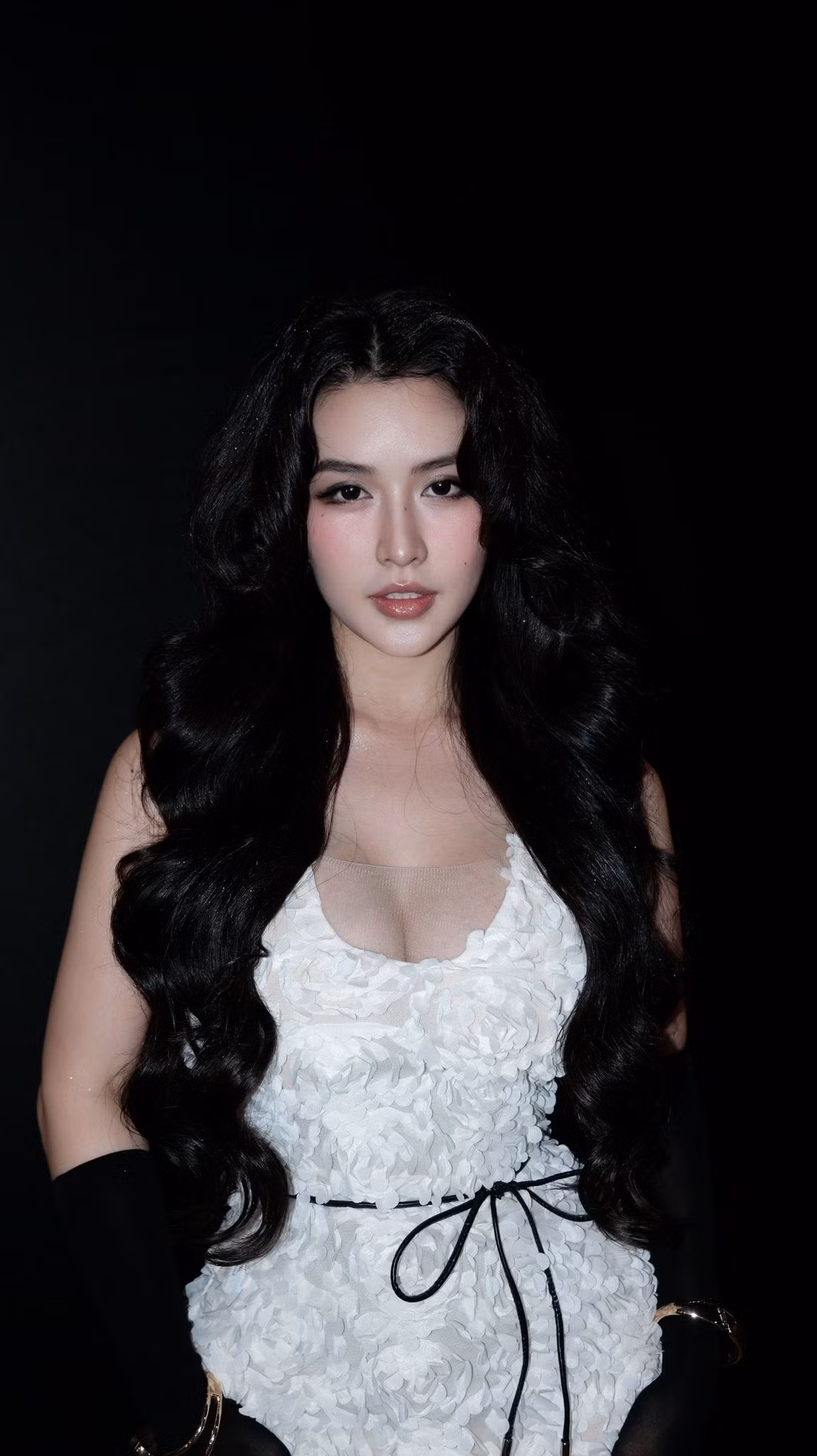 Điểm nhấn thú vị là đôi găng tay đen dáng dài kết hợp cùng vòng tay vàng, tạo sự đối lập màu sắc đầy nghệ thuật. Mỗi chuyển động và ánh nhìn của cô đều toát lên vẻ tự tin, trưởng thành và quyến rũ.