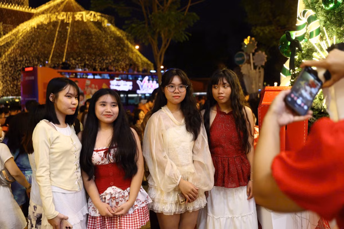 Nhiều nhóm bạn trẻ, các cặp đôi và gia đình có mặt từ sớm, không ngại xếp hàng để có vị trí thuận lợi, ghi lại bức hình kỷ niệm đêm Giáng sinh.