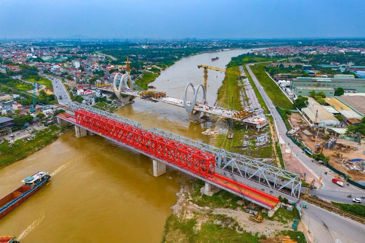 Nhìn từ cầu Đuống cũ, công trình mới với các trụ cầu và nhịp cầu lớn đang dần hoàn thiện. Khi đưa vào sử dụng, cầu mới sẽ thay thế chức năng giao thông đường bộ của cây cầu đã tồn tại hơn một thế kỷ.(Ảnh: Văn Đoan)
