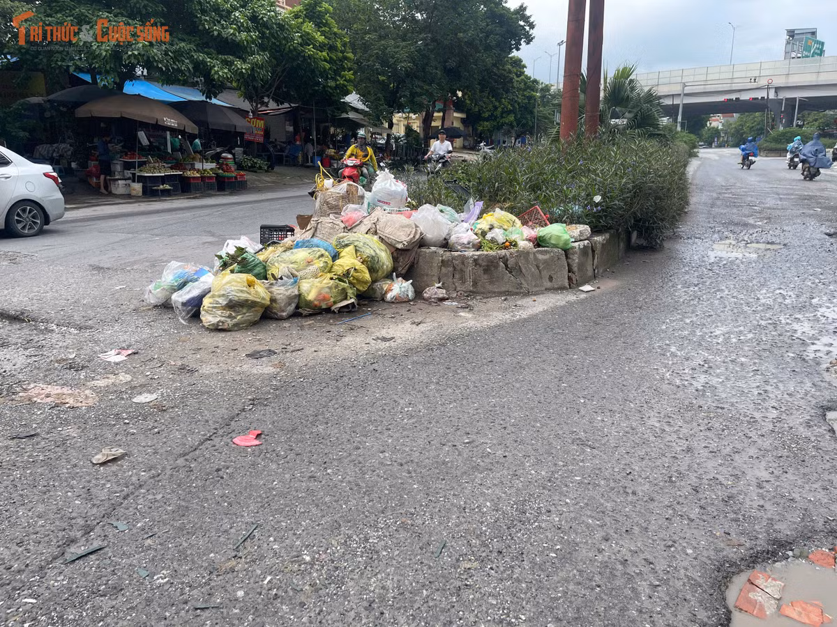 Một khu vực tập kết rác nằm ngay trên mặt đường khiến lòng đường bị thu hẹp. Rác thải tồn đọng không chỉ gây mất mỹ quan mà còn ảnh hưởng đến việc lưu thông của các phương tiện qua khu vực.