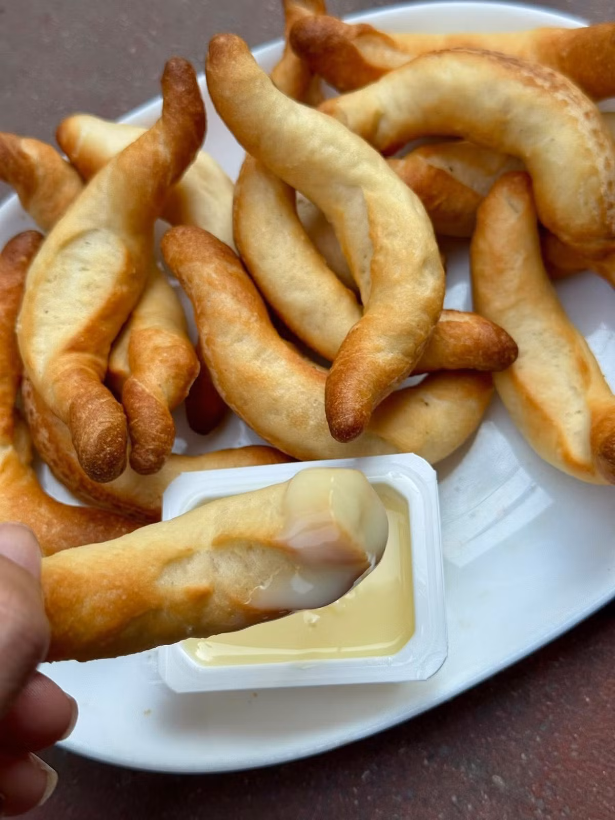 Tuy nhiên, loại bánh đang gây chú ý gần đây lại có tạo hình ngẫu hứng, khác hẳn kiểu bánh mì mini thông thường. Bột được vê dài rồi uốn cong nhẹ trước khi đem nướng, tạo ra những chiếc bánh có hình dạng tự nhiên, không đồng nhất. Ảnh Internet