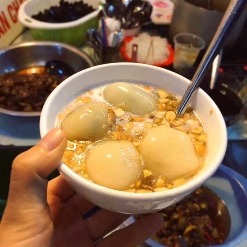 Khi đêm xuống, phố cổ sáng lên bằng hơi ấm của những quán chè nóng. Chí mà phù, bánh trôi tàu, lục tàu xá – ba món chè gốc Hoa đã thành “biểu tượng” của mùa đông Hà Nội. Ở Hàng Giầy hay Hàng Cân, những bát chè đen sánh, ngọt nhẹ và cay thơm gừng khiến người ta như trở lại tuổi thơ. Mỗi khi gió mùa về, hương gừng, mè, đậu xanh… hoà vào không khí se lạnh, tạo nên một “mùa hương” rất riêng của phố. Ảnh MIA