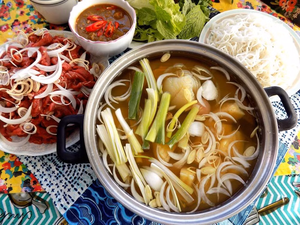 Phần nước nhúng được xem là “xương sống” của món ăn. Nước dừa tươi cho vào nồi đun nóng, sau đó nêm giấm, đường phèn và hạt nêm từng chút một để đạt vị chua ngọt thanh dịu. Khi nước sôi, cho sả đập dập, gừng thái sợi, hành tây, dứa, ớt và cùi dừa thái sợi vào, đun thêm vài phút là có thể dùng ngay. Việc nêm giấm từ từ giúp nước nhúng không bị hắc, giữ được mùi thơm dễ chịu. Ảnh minh họa