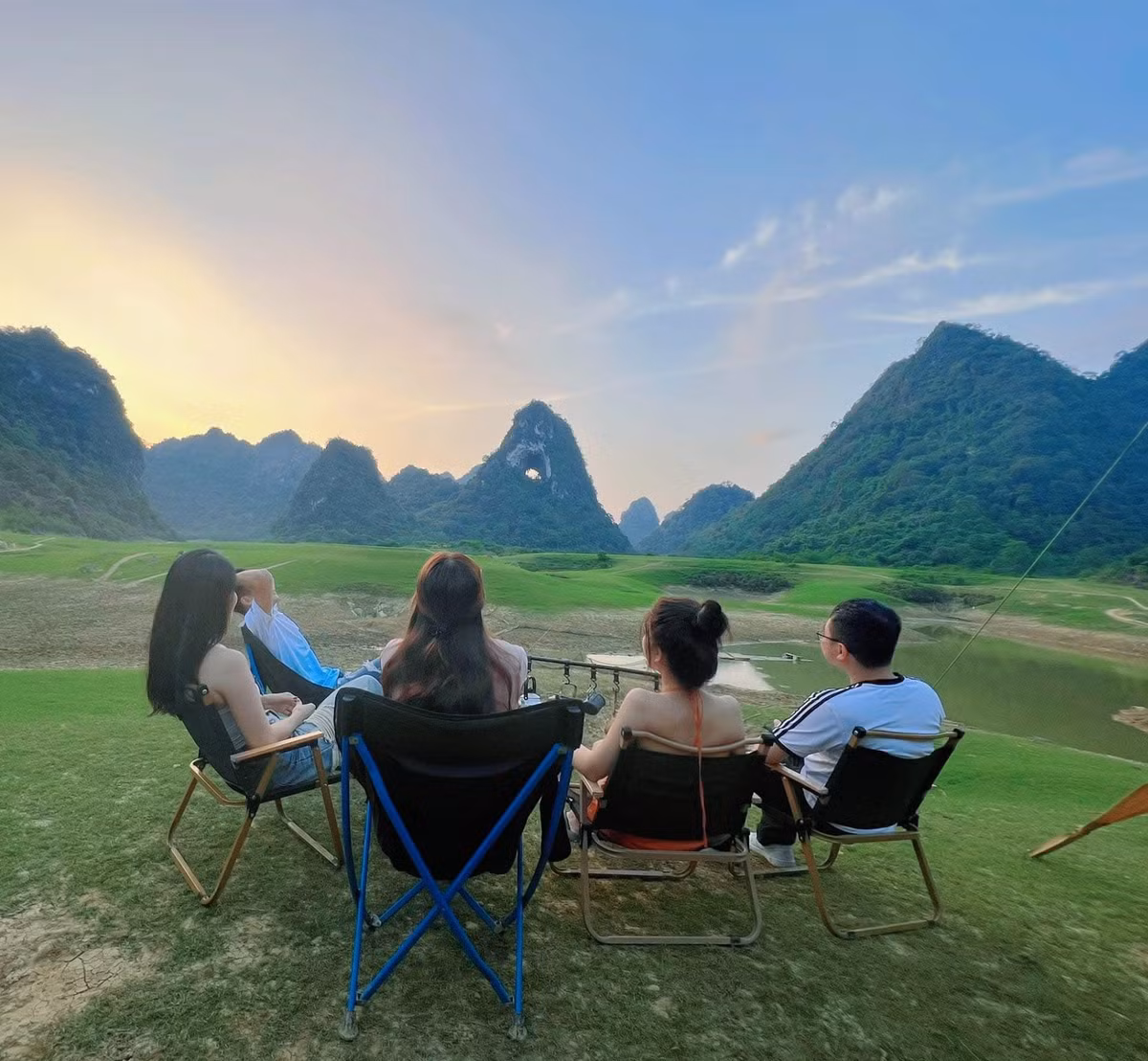 Bao quanh núi là thảm cỏ xanh mướt trải dài, dòng suối uốn lượn và những cánh rừng thưa, tạo nên một khung cảnh yên bình, tách biệt khỏi nhịp sống thường nhật. Ảnh