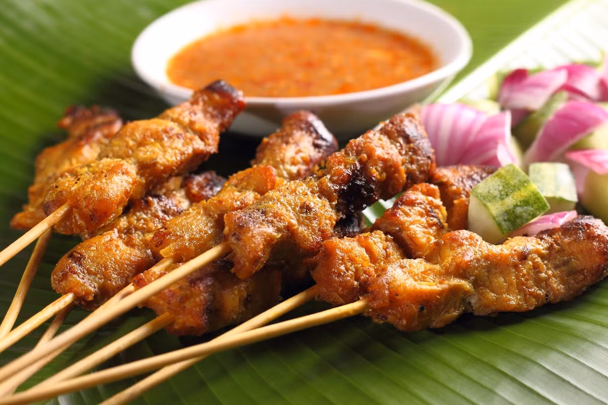 Satay là món ăn vặt phổ biến của Thái Lan, với thịt xiên nướng (thường là thịt gà, lợn hoặc bò) được tẩm ướp gia vị đặc biệt, ăn kèm với nước sốt đậu phộng béo ngậy. Món ăn này rất thơm ngon, phù hợp làm món ăn nhẹ hay khai vị. Ảnh Chill Thai
