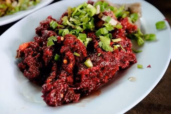 Nếu du khách nghĩ bò tái là giới hạn cuối cùng của ẩm thực sống, thì Larb Leuat Neua (ลาบเลือดเนื้อ) sẽ khiến du khách phải suy nghĩ lại. Món ăn này gồm thịt bò sống thái lát mỏng, chan lên lớp tiết tươi đỏ au, trộn cùng rau thơm, hành lá, ớt và các loại gia vị cay nồng. Ảnh Eating Thai Food