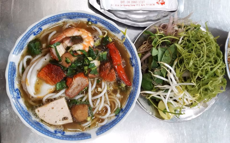 Dù có biến tấu đôi chút tùy vùng, bún mắm vẫn giữ hồn cốt đặc trưng: nước lèo đậm đà nhưng không gắt, hải sản tươi ngon, rau sống tươi xanh, tạo cân bằng hương vị hoàn hảo. Nhiều thực khách chia sẻ vui rằng: “Ai không quen ngửi mùi mắm thì bỏ chạy, nhưng nếu ăn được thì hai tô vẫn chưa đã”. Ảnh MIA