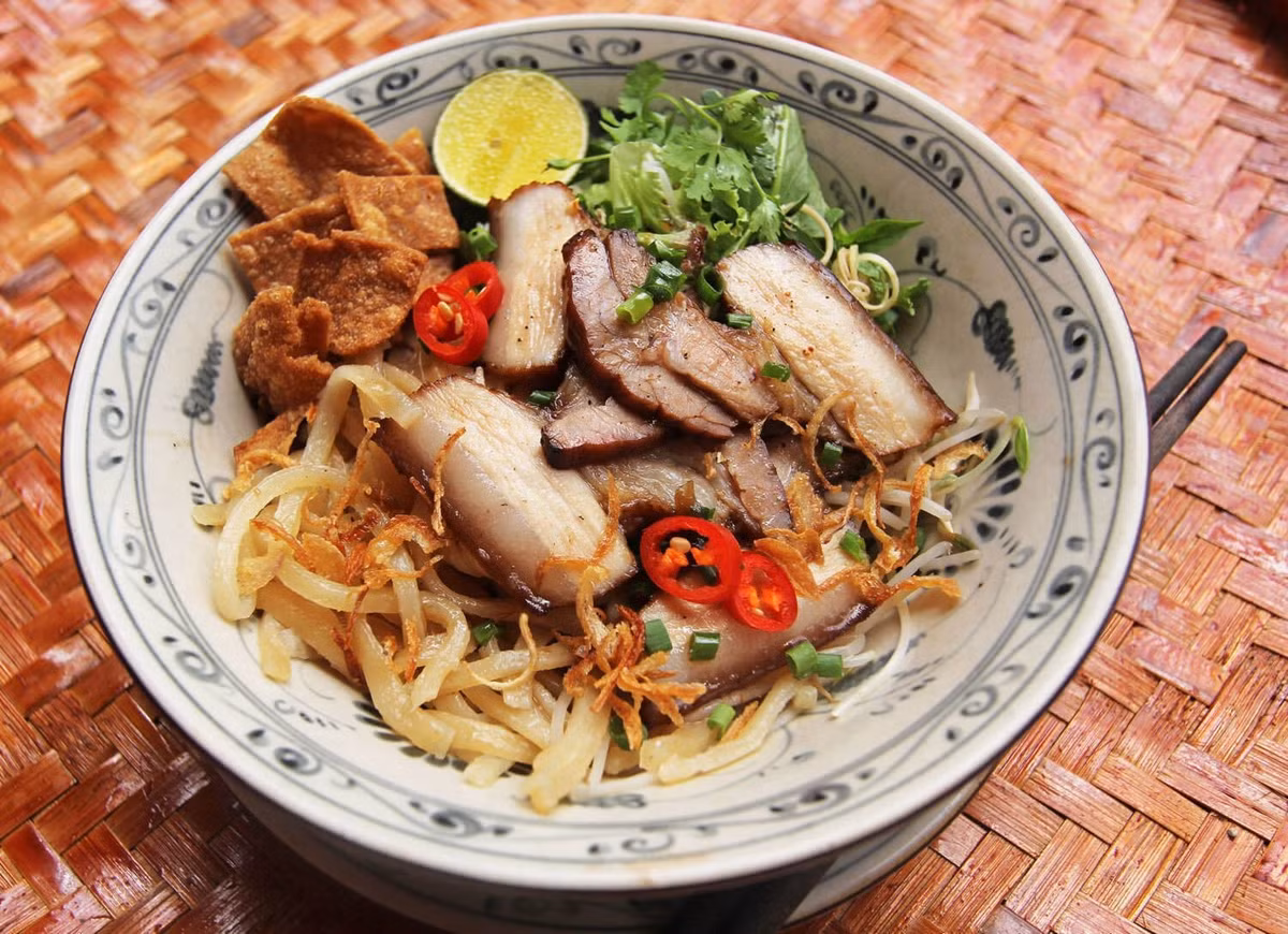 Dù nổi tiếng ở Hội An, cao lầu vẫn xuất hiện nhiều tại Đà Nẵng và được lòng du khách. Sợi mì dai đặc trưng ăn cùng thịt xá xíu, tóp mỡ giòn và rau sống tạo nên món ăn vừa lạ vừa quen. Ảnh internet
