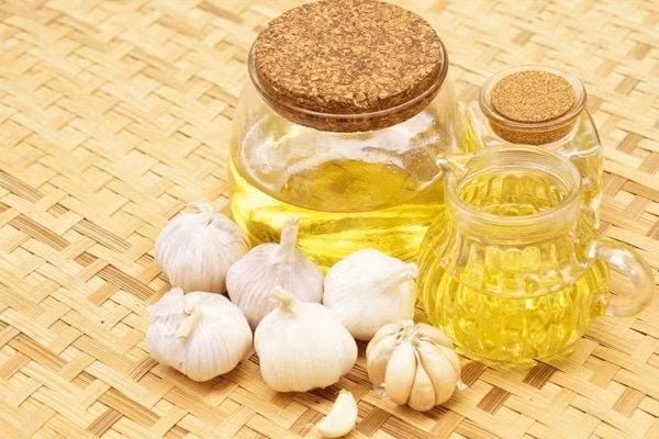 Một cách tiện lợi khác là dùng dầu tỏi. Loại dầu này vừa tăng hương vị món ăn vừa mang lại lợi ích tương tự tỏi tươi. Chỉ cần đập dập vài tép tỏi, đun nhỏ lửa cùng dầu ô liu đến khi tỏi vàng nhạt rồi lọc bỏ phần xác, bảo quản trong lọ kín. Dầu tỏi có thể dùng trộn salad, rưới lên rau củ nướng hoặc phết bánh mì, đồng thời giúp giảm nghẹt mũi và hỗ trợ lưu thông máu khi dùng ấm. Ảnh minh họa