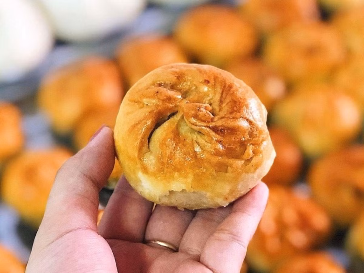 Bánh xíu páo có hình dáng tròn, vỏ ngoài giòn rụm, vàng óng ánh và được phủ một lớp vừng thơm bùi. Nhân bánh là sự kết hợp hoàn hảo giữa thịt xá xíu, mộc nhĩ, trứng cút và hành phi. Ảnh Latravel