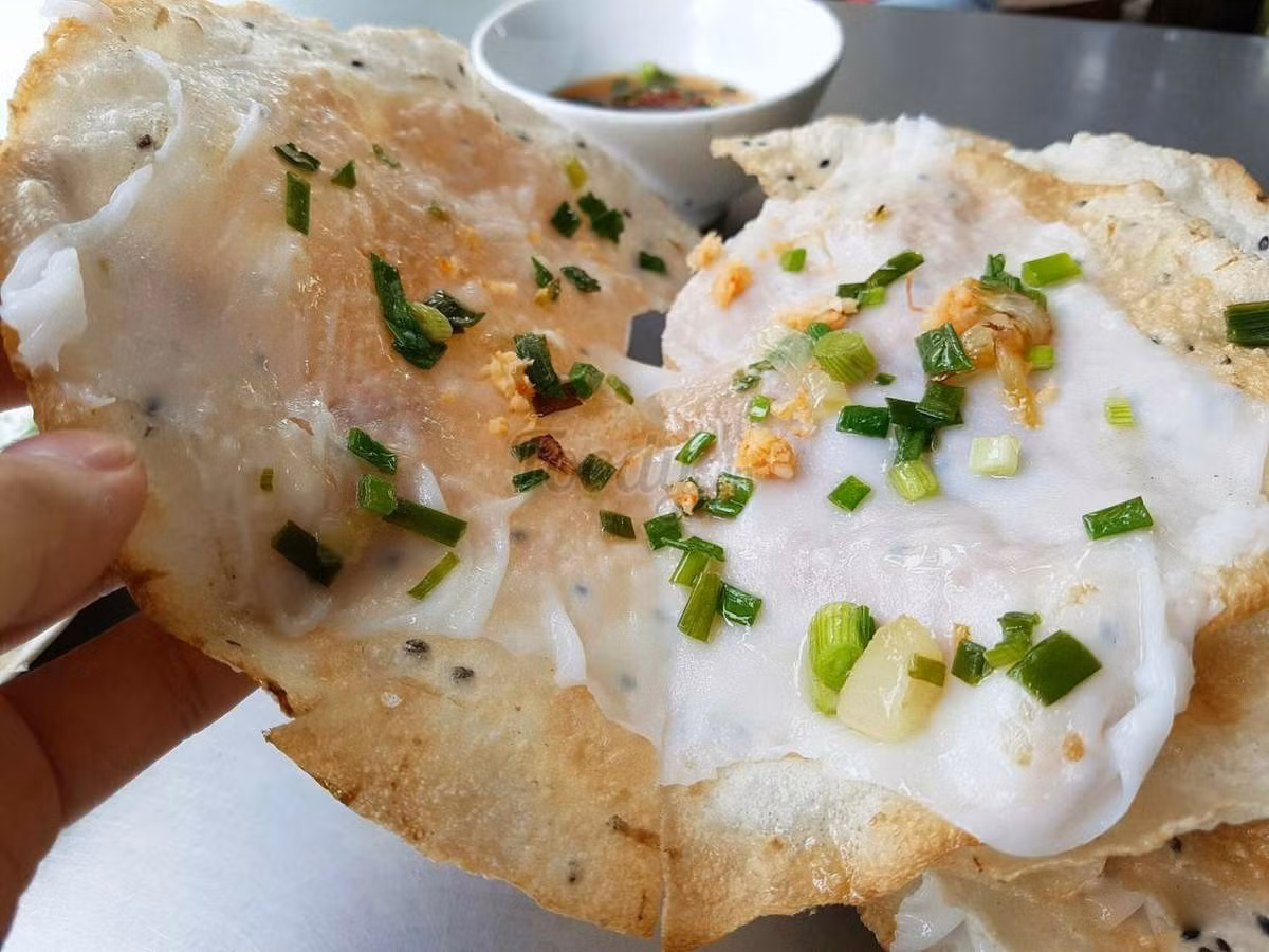 Bánh đập Nha Trang hấp dẫn bởi sự kết hợp giữa bánh ướt mềm và bánh tráng nướng giòn, ăn kèm tôm khô, mỡ hành, ruốc xay, chấm mắm nêm đậm đà. So với các tỉnh miền Trung, món này tại Nha Trang có topping đa dạng và hương vị đậm đà hơn. Gợi ý địa chỉ: bánh đập Hồng Lĩnh (16A Hồng Lĩnh), quán sân banh (đường 19/5, KĐT Vĩnh Điềm Trung), quán Cô Hà (Km4, đường 23/10). Ảnh MIA