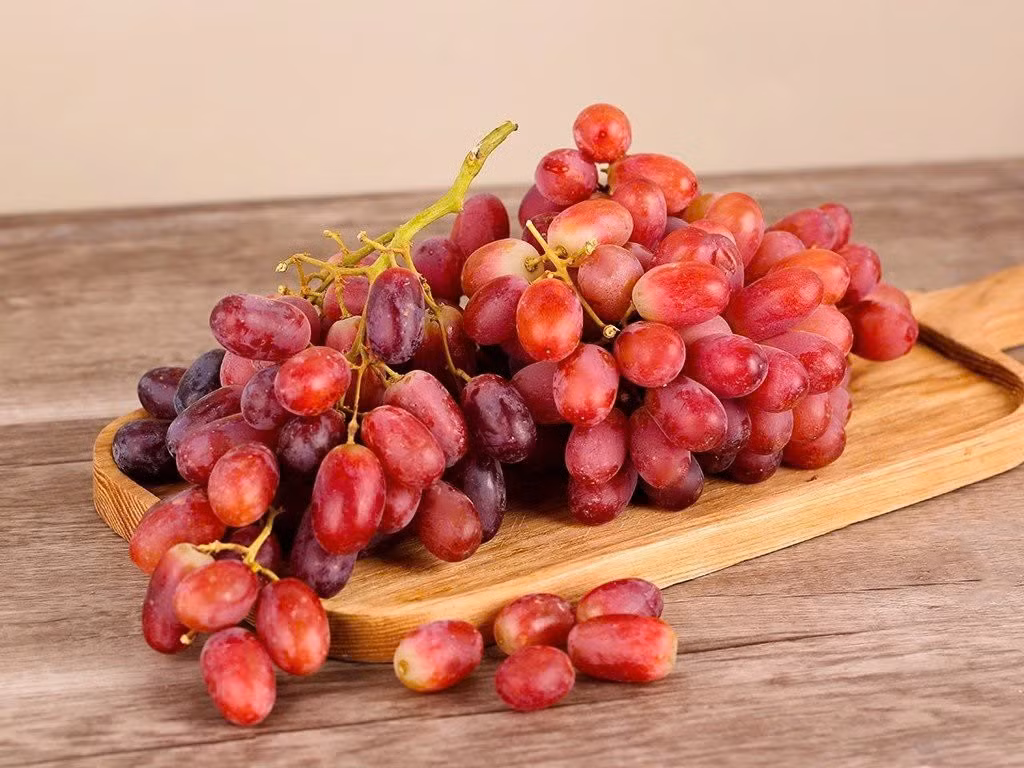 Không thể không nhắc đến nho đỏ – loại quả chứa resveratrol trong vỏ và hạt, được ví như “lá chắn chống lão hóa” tự nhiên. Resveratrol giúp bảo vệ tế bào da khỏi tác hại của tia UV và môi trường, đồng thời ổn định cấu trúc collagen, làm giảm nếp nhăn và cải thiện độ đàn hồi. Thường xuyên ăn nho hoặc uống nước ép nho đỏ giúp da hồng hào, khỏe mạnh từ bên trong. Ảnh minh họa