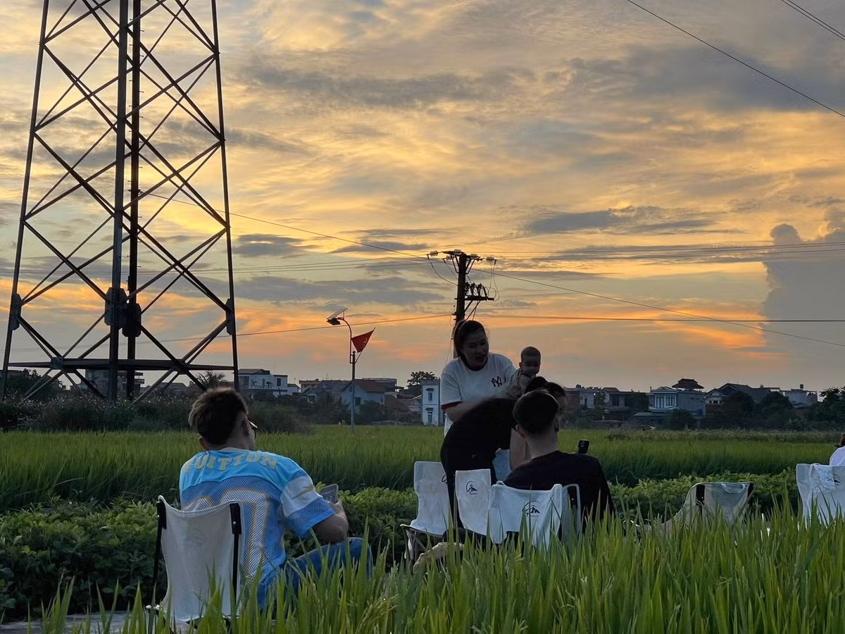 Quán được dựng đơn giản với vài bộ bàn ghế, ô che nắng và khung cảnh hoàn toàn mở xung quanh là những thửa ruộng lúa đang "thì con gái", trải dài đến tận chân trời. Ảnh Vietnamet