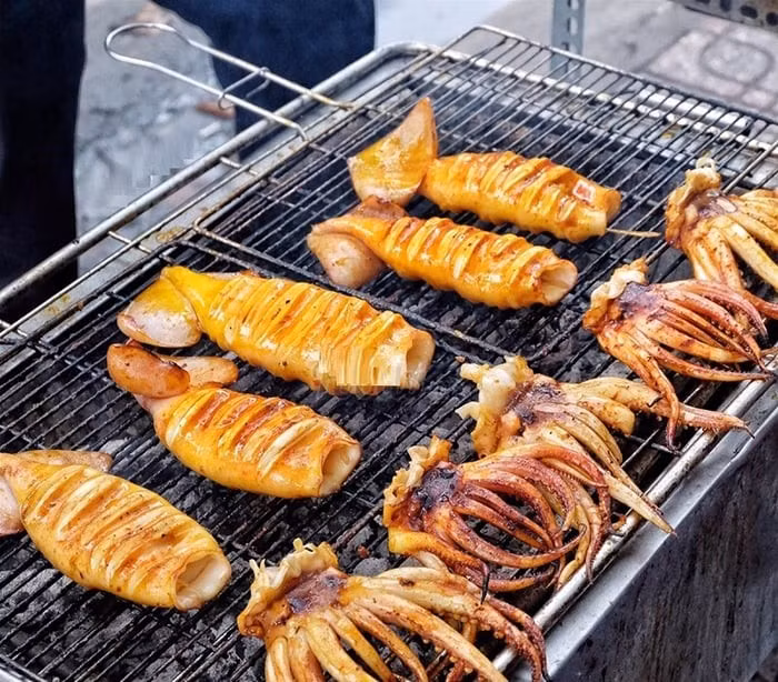 Cửa Lò là một địa điểm tuyệt vời để thưởng thức các món mực tươi, và mực nhảy nướng là món ăn không thể bỏ qua. Những con mực tươi ngon, được nướng trên than hồng, tỏa ra mùi thơm nức mũi, thịt mực ngọt và dai. Món mực nướng ăn kèm muối tiêu chanh hoặc tương ớt, mang lại sự kết hợp hoàn hảo giữa vị cay, mặn và ngọt, làm hài lòng bất kỳ thực khách nào. Ảnh dulichVietNam