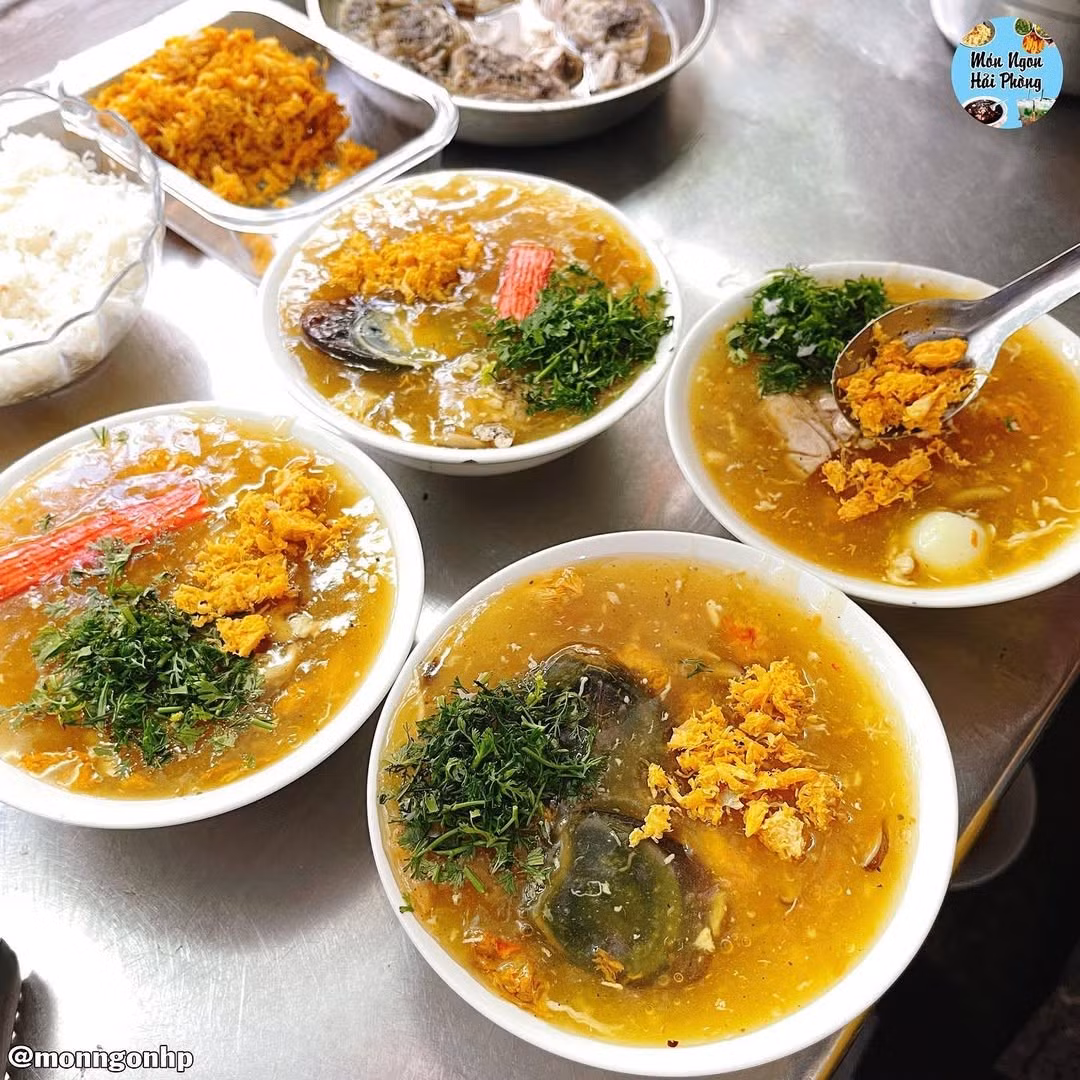 Súp cua Hải Phòng là sự kết hợp hoàn hảo giữa hương vị hải sản tươi ngon và nguyên liệu phong phú: thịt ức gà, xương ống, ngô ngọt, nấm đông cô, nấm tuyết, trứng gà, trứng cút, óc heo và bột bang. Điểm nhấn đặc biệt là cua bể tươi rói, thịt ngọt, dai và thơm, giúp món súp trở nên khác biệt so với các nơi khác. Khi ăn kèm hạt tiêu và rau mùi thái nhỏ, súp cua bốc khói nghi ngút trở thành món ăn nóng hổi lý tưởng cho mùa đông. Ảnh monngonhaiphong