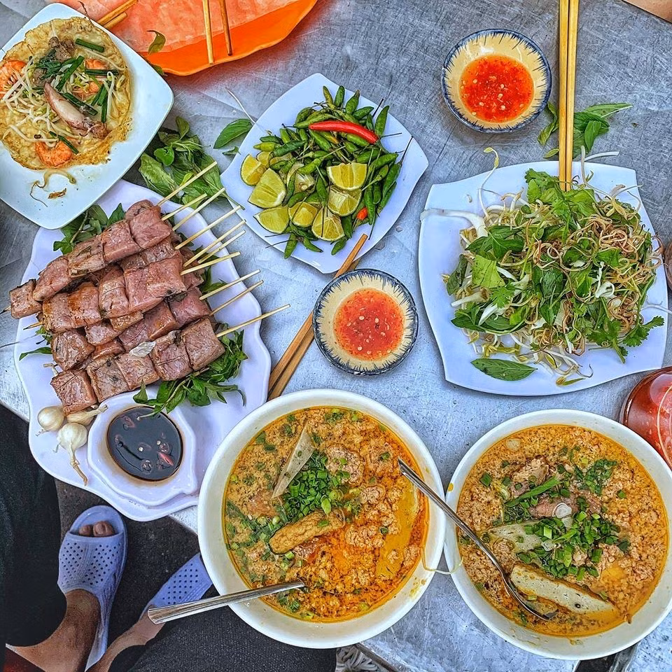 Ẩm thực Quy Nhơn là một điểm cộng lớn đối với du khách tự túc. Những món ăn như bánh hỏi lòng heo, bún chả cá hay bánh xèo tôm nhảy mang đậm phong vị miền Trung, dễ tìm thấy ở các quán nhỏ dọc đường Nguyễn Huệ, Trần Phú hoặc khu vực chợ Đầm. Ngoài ra, đặc sản nem chợ Huyện, tré Bình Định hay hải sản tươi sống từ các làng chài như Nhơn Lý, Nhơn Hải đều là những lựa chọn đáng thử. Ảnh amthucquynhon