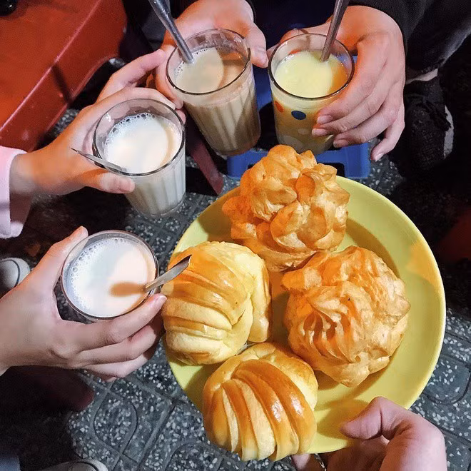 Trong không khí lạnh về đêm, “combo” bánh ngọt và sữa nóng trở thành lựa chọn quen thuộc của nhiều người. Tại chợ đêm, du khách có thể dễ dàng tìm thấy các loại bánh như bánh su kem, bánh tiêu, bánh rán… ăn kèm sữa đậu nành, sữa đậu phộng hay sữa mè đen nóng hổi. Ngồi bên ly sữa bốc khói, nhâm nhi chiếc bánh ngọt và trò chuyện cùng bạn đồng hành mang lại cảm giác thư thái rất riêng của Đà Lạt. Ảnh Internet