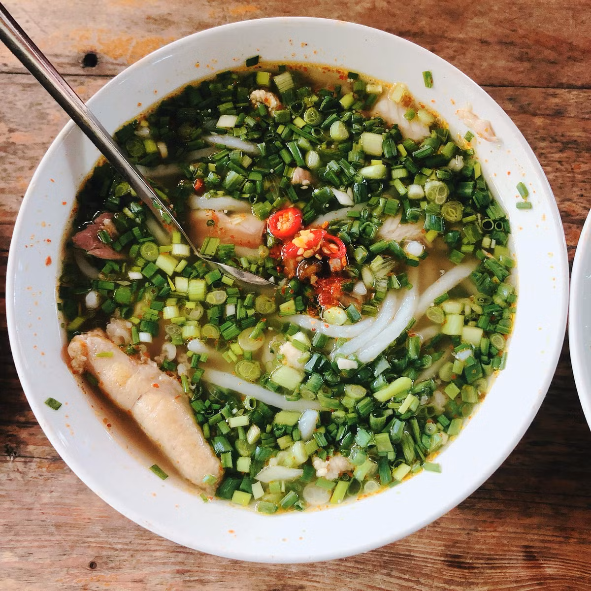 Điểm đặc biệt khiến món cháo này trở nên khác biệt là không thể ăn bằng thìa mà phải dùng… đũa. Những sợi cháo dai và dày khiến thực khách phải gắp từng đũa, vừa ăn vừa xuýt xoa vì vị cay và hơi nóng bốc nghi ngút. Người Quảng Trị vốn thích ăn cay nên món cháo này thường “nóng hai lần”: nóng vì nhiệt và nóng vì ớt. Ảnh Cao Hoàng Tú Anh