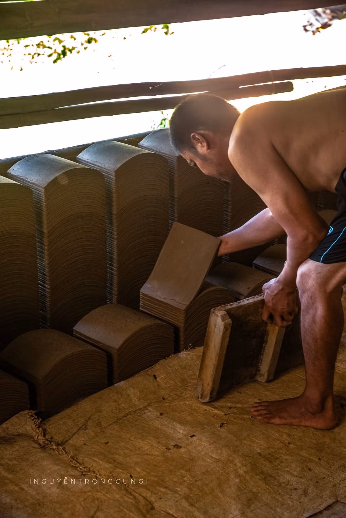 Để cho ra đời những viên ngói đạt chất lượng, người thợ phải trải qua nhiều công đoạn công phu. Đất sét được chọn từ những vùng ruộng sâu có độ dẻo cao, sau đó được ủ khoảng 20 ngày để đạt độ “chín” tự nhiên. Tiếp đến là khâu giẫm đất, đóng khuôn, phơi khô rồi mới đem nung. Ảnh Nguyễn Trọng Cung