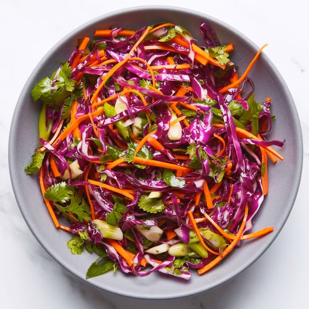 Salad bắp cải tím và táo xanh mang đến sự kết hợp giữa chất xơ và hợp chất indole-3-carbinol, giúp gan tăng sản xuất enzym giải độc. Ảnh minh họa