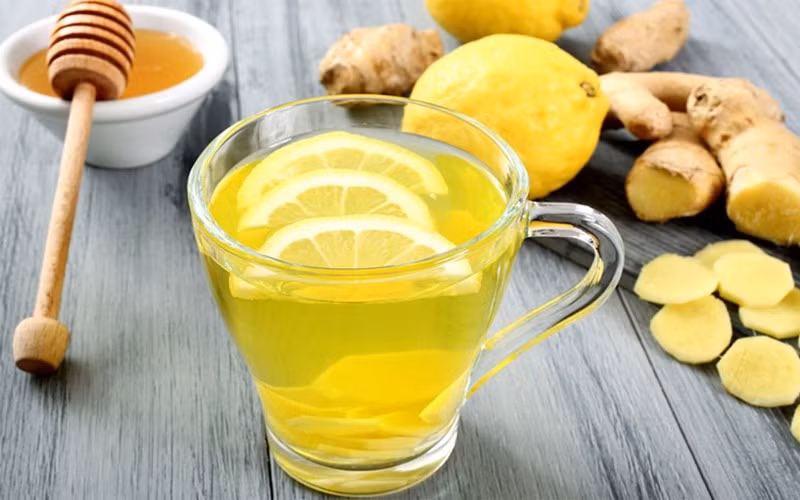 Cách pha rất đơn giản: chỉ cần ngâm vài lát gừng trong nước ấm khoảng 10 phút, sau đó thêm nước cốt chanh và một thìa mật ong, khuấy đều và uống khi còn ấm. Loại trà này giúp giữ ấm, phòng cảm cúm và giảm viêm họng hiệu quả. Tuy nhiên, người bị viêm loét dạ dày hay phụ nữ mang thai nên hạn chế dùng vì chanh có tính acid cao, dễ gây kích ứng dạ dày. Ảnh minh hoạ