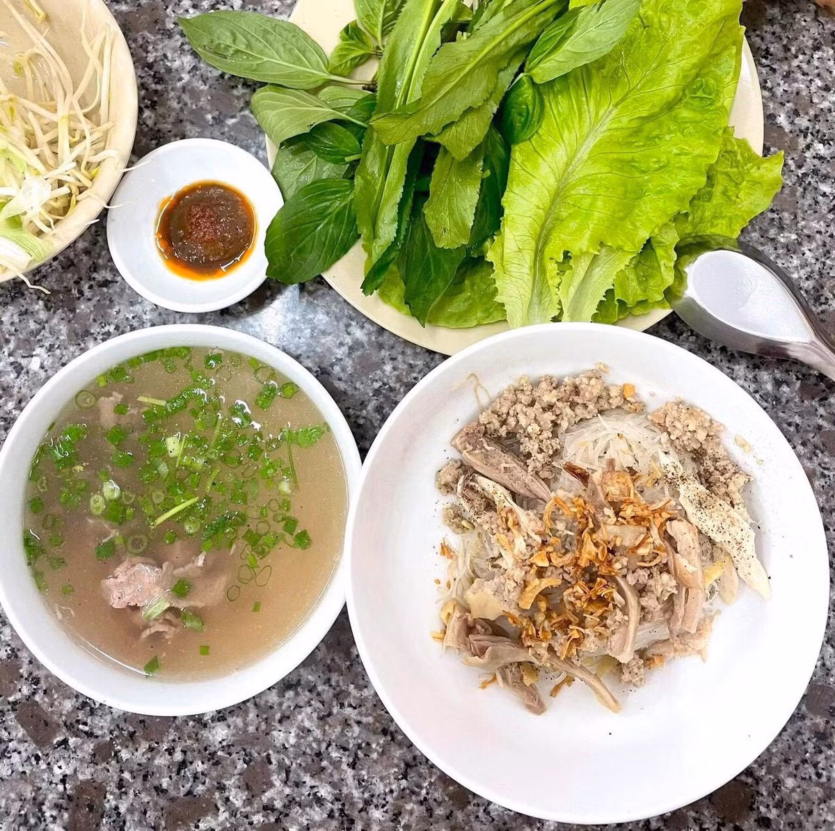 Ăn phở khô Gia Lai là một trải nghiệm chậm rãi và tinh tế. Đĩa rau sống tươi xanh gồm giá đỗ, húng quế, rau mùi, xà lách luôn có mặt để thực khách tùy ý thêm vào, làm dậy lên hương thơm mộc mạc của món ăn. Ảnh nguồn Internet