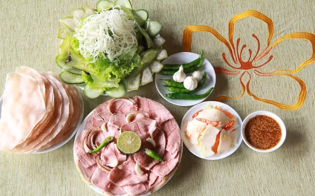 Bánh tráng dùng để cuốn thường là loại nhỏ, mỏng, dai – sản xuất từ các lò bánh nổi tiếng địa phương. Nước chấm đóng vai trò quan trọng, làm nổi bật vị ngon của thịt bê và cân bằng hương vị khi ăn.