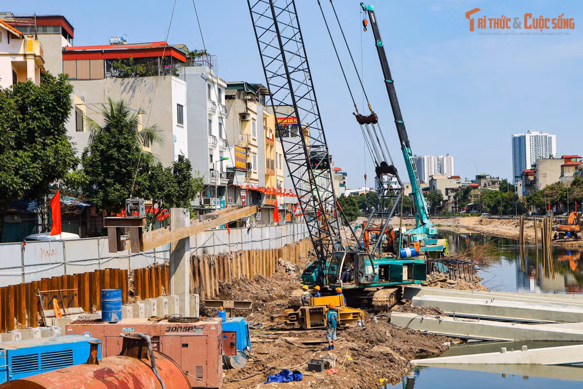 Tại công trường, nhiều mũi thi công được triển khai đồng loạt. Các thiết bị chuyên dụng như cần cẩu, máy đào, hệ thống ép cọc và các thiết bị phục vụ thi công kè sông hoạt động liên tục dọc tuyến.