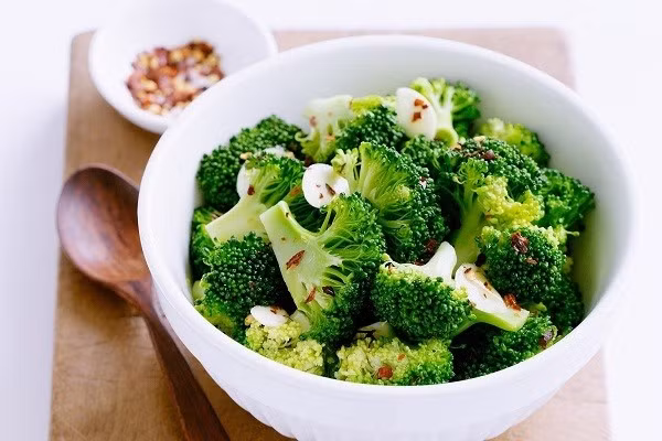 Cách chế biến: Ngâm bông cải trong nước muối loãng, trụng qua nước sôi, sau đó xào nhanh với tỏi, nêm dầu hào và một chút muối. Một mẹo nhỏ là cho vài giọt dầu ăn khi trụng để giữ màu xanh tươi. Bông cải xanh có thể nấu sẵn, để tủ lạnh, dùng nhanh khi đói buổi tối, tiện lợi và hạn chế tăng cân. Ảnh minh hoạ