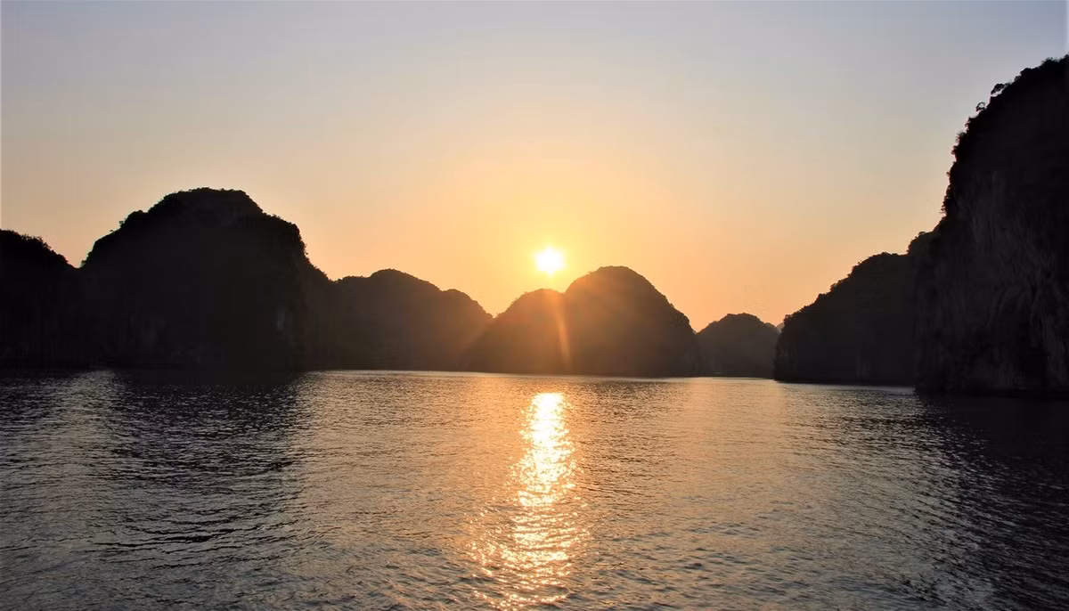 Từ khoảng 16h30 đến 16h45, mặt trời dần khuất xuống sau những vách núi đá vôi, phản chiếu sắc trời lung linh lên mặt biển. Ảnh Checkin Việt Nam