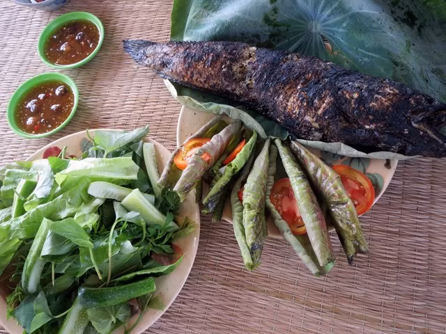 Không cầu kỳ trong chế biến, không nhiều nguyên liệu phức tạp, cá lóc nướng trui cuốn lá sen non vẫn khiến bao thực khách say mê nhờ vào sự mộc mạc và đậm đà bản sắc miền Tây. Ảnh amthuc