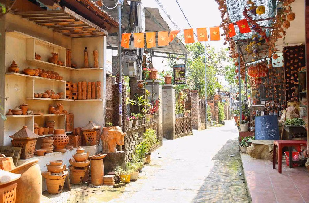 Làng gốm cách phố cổ Hội An chỉ khoảng 3 km, du khách có thể di chuyển bằng xe máy hoặc xe đạp. Đi xe đạp không chỉ thân thiện với môi trường mà còn giúp tận hưởng khung cảnh yên bình, từ những dãy nhà cổ kính đến hàng cây xanh mướt ven sông. Ảnh Xanh SM