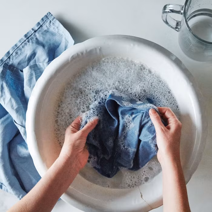 Để hạn chế phai màu, không giặt áo quá thường xuyên. Khi giặt, nên lộn trái áo, dùng nước lạnh và chọn chế độ nhẹ. Tránh nước nóng, lực quay mạnh và ánh nắng trực tiếp khi phơi. Ảnh minh hoạ