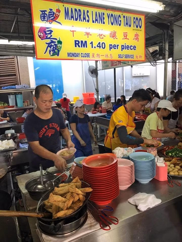 Ẩm thực phố Tàu Kuala Lumpur cũng ghi dấu với quán Madras Lane Yong Tau Foo, nơi đã bán món chả cá nhồi suốt hơn 70 năm. Những miếng chả cá được nhồi vào cà tím, ớt đỏ, đậu bắp hay tàu hủ chiên, ăn kèm loại tương đặc trưng của quán. Điểm nhấn là bát nước dùng trong, ngọt thanh, được hầm từ xương cá, giúp món ăn cân bằng hương vị. Quán nằm trong khu phố Tàu, mở cửa từ 10h30 đến 14h và nghỉ vào thứ Hai. Ảnh Internet