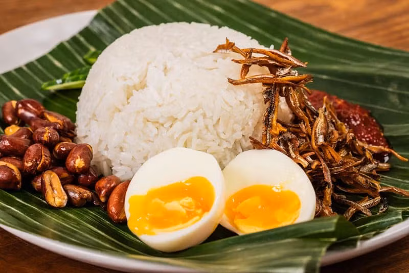 Nếu muốn thưởng thức bữa sáng chuẩn vị Malaysia, nhiều người tìm đến quán cơm dừa Nasi Lemak Tanglin, được thành lập từ năm 1948. Cơm dừa thơm lừng ăn kèm mực xào sambal, gà rán hoặc bò rendang là lựa chọn quen thuộc của người dân địa phương. Quán thường xuyên đông khách từ sáng sớm và đã được giới thiệu trong cẩm nang Michelin. Nasi Lemak Tanglin mở cửa từ 7h đến 12h30 mỗi ngày tại khu Kompleks Makan Tanglin, Jalan Cenderasari. Ảnh MIA