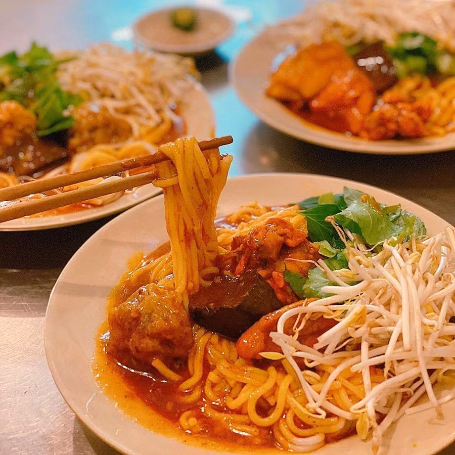 Một tô bánh tầm cay hoàn chỉnh sẽ có sợi bánh mềm, thấm đẫm nước cà ri béo cay, ăn kèm xíu mại, trứng non hoặc thịt gà, thêm ít rau sống thái nhỏ. Ảnh MIA