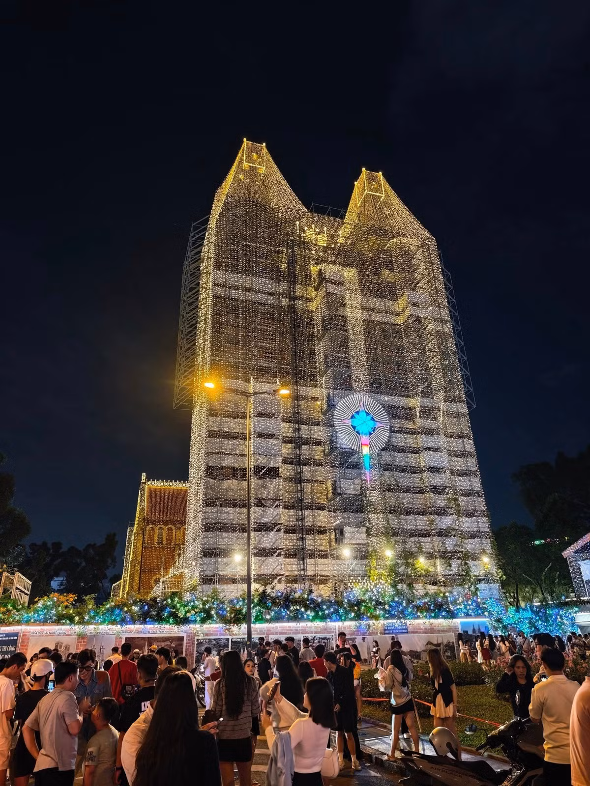 Không gian xung quanh nhà thờ trở nên huyền ảo, tạo phông nền hoàn hảo cho những bức ảnh Giáng sinh. Dòng người đổ về từ chiều tối để chiêm ngưỡng và lưu giữ khoảnh khắc bên công trình hơn 140 năm tuổi. Ảnh Toan Dominico