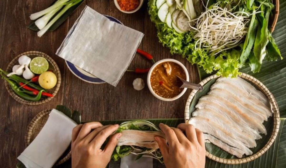 Một món khác khiến nhiều du khách nhớ mãi là bánh tráng cuốn thịt heo. Thịt heo luộc thái lát mỏng, cuốn cùng bánh tráng, rau sống rồi chấm mắm nêm. Sự hòa quyện giữa vị ngọt của thịt, vị tươi của rau và vị đậm của nước chấm tạo nên nét riêng khó trộn lẫn. Ảnh wondertour