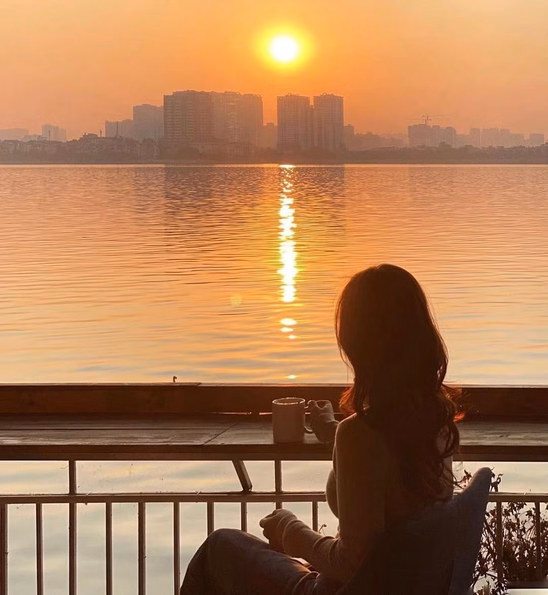 Dừng chân tại quán cà phê ven hồ, thưởng thức ly latte nóng và ngắm mặt trời lặn, giữa không khí se lạnh cùng hương hoa sữa thoang thoảng, là khoảnh khắc khiến ai cũng muốn lưu giữ trọn vẹn. Ảnh nguoihanoi