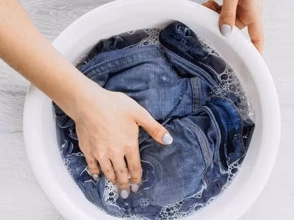 Trước khi tiến hành, cần làm sạch áo, đảm bảo không còn bụi bẩn hoặc chất tẩy rửa. Sau đó, pha thuốc nhuộm theo đúng hướng dẫn trên bao bì, ngâm áo trong dung dịch khoảng 2–3 tiếng, thỉnh thoảng đảo đều để màu lên đồng nhất. Cuối cùng, giặt sạch lại bằng nước lạnh và phơi nơi thoáng gió, tránh ánh nắng trực tiếp để giữ màu lâu phai. Ảnh minh hoạ