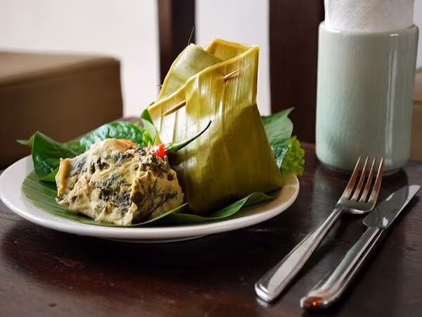 Cá hấp là một trong những món đặc sản Lào mang đậm phong vị riêng. Cá tươi được lọc xương, thái miếng nhỏ, trộn cùng hành, tỏi, ớt, rau thơm rồi bọc lá chuối, hấp trong lồng tre. Khi chín, thịt cá mọng nước, dai ngon, thơm mùi lá chuối, hương vị đậm đà hài hòa, mang đến trải nghiệm ẩm thực đặc sắc cho du khách. Ảnh Sakos