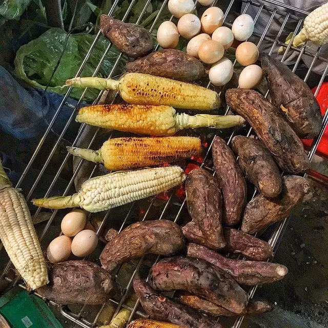 Và sẽ thật thiếu nếu không nhắc đến khoai nướng, ngô nướng – những “ngọn lửa nhỏ” của mùa đông. Ở ngõ Tạm Thương, Hàng Da hay chợ Hàng Bè, từng bắp ngô vàng ruộm, từng củ khoai bốc khói nghi ngút khiến đôi tay tê cóng cũng trở nên ấm áp. Ảnh Tundidauthe