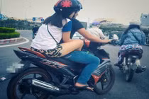 Khó coi gái trẻ đi xe máy gác chân lên đùi bạn trai