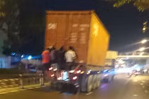 Rợn người cảnh 4 thanh niên đu mình sau container đang chạy